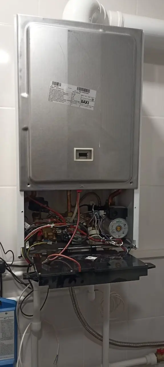 Открытая передняя панель котла с видимой наклейкой BAXI и циркуляционным насосом Wilo